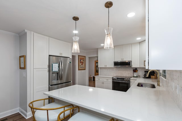 kitchen with appliances with stainless steel finishes, kitchen peninsula, white cabinets, and sink