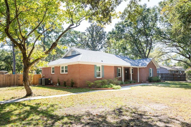 view of front of property with a front yard and central AC unit