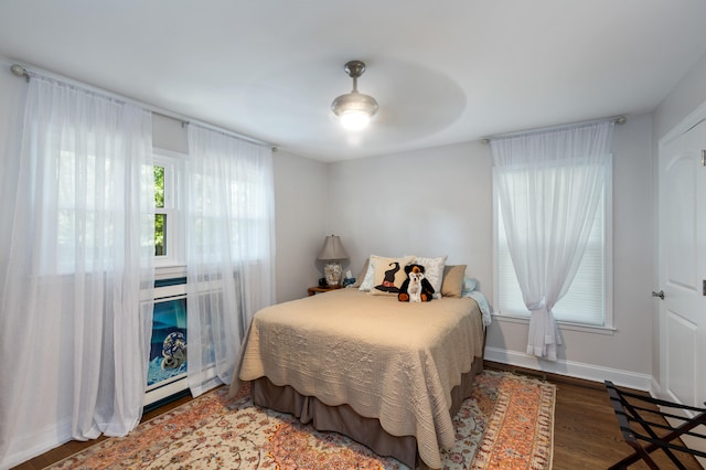 bedroom with dark hardwood / wood-style floors and ceiling fan