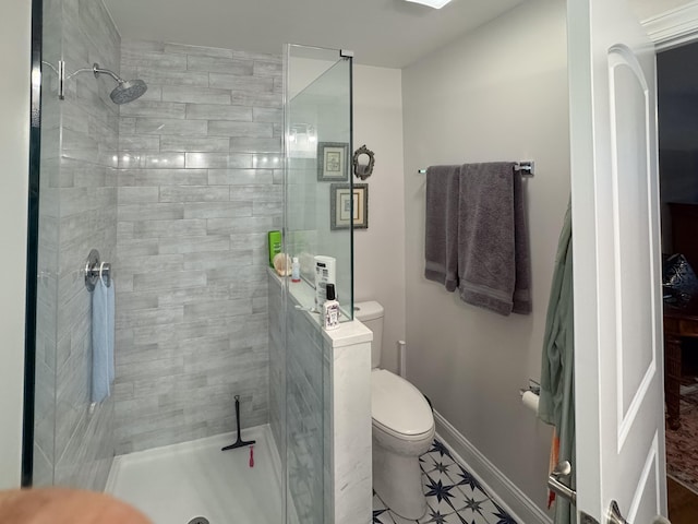 bathroom with toilet, tile patterned floors, and tiled shower