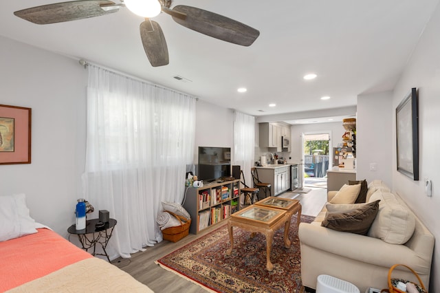 living room with light hardwood / wood-style flooring and ceiling fan