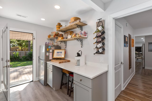 interior space featuring light hardwood / wood-style floors, stainless steel refrigerator, and gray cabinets