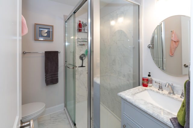 bathroom featuring vanity, a shower with shower door, and toilet