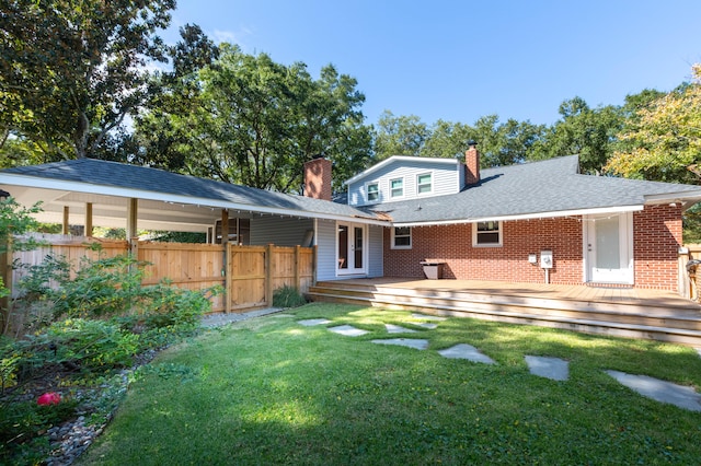 back of house with a wooden deck and a lawn