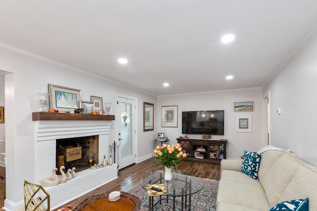 living room featuring crown molding, a fireplace, and wood-type flooring