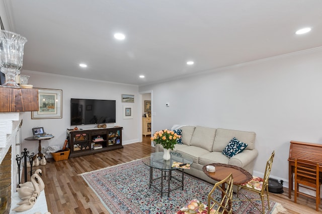 living room featuring crown molding, a brick fireplace, and light wood-type flooring