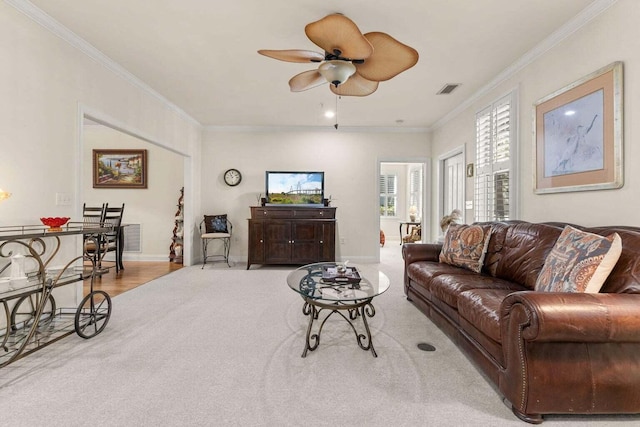 living area with ornamental molding, ceiling fan, and baseboards