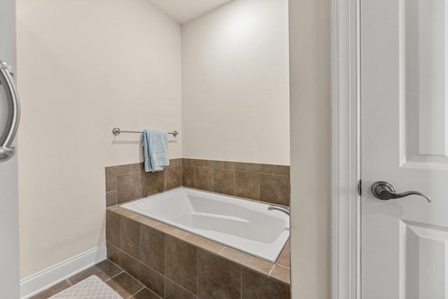 full bathroom featuring a garden tub, baseboards, and tile patterned flooring