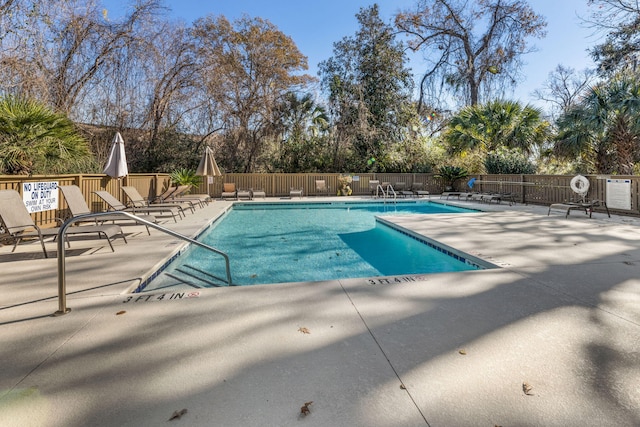 community pool featuring a patio and fence