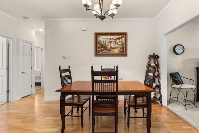 dining room featuring ornamental molding, a chandelier, light wood finished floors, and baseboards