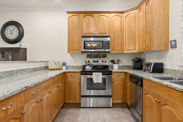 kitchen with stainless steel appliances, light tile patterned floors, light stone counters, and brown cabinets