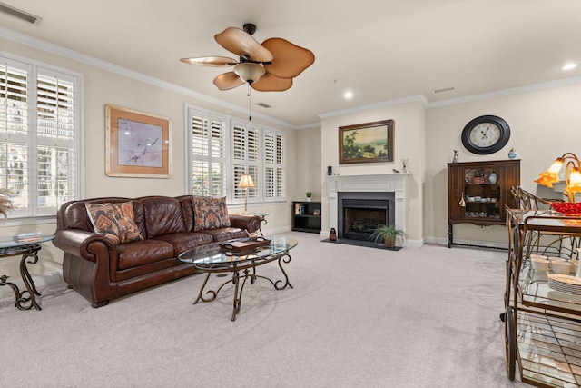 carpeted living area with a fireplace with flush hearth, ornamental molding, baseboards, and a ceiling fan