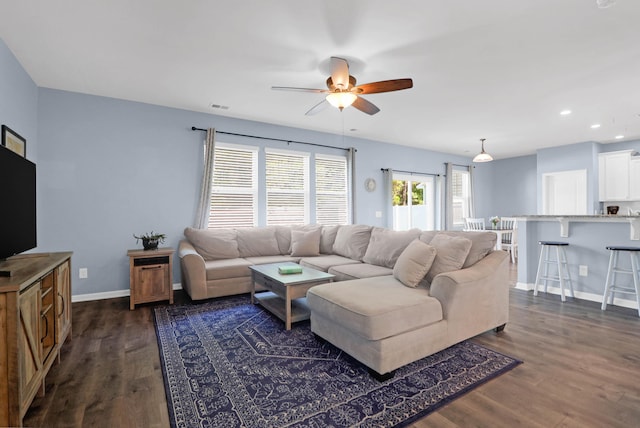 living room with dark hardwood / wood-style flooring and ceiling fan