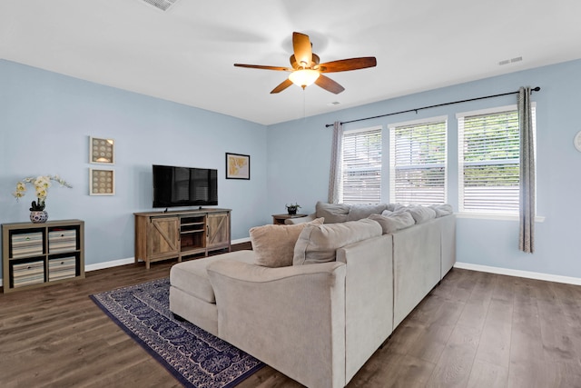 living room with ceiling fan and dark wood-type flooring