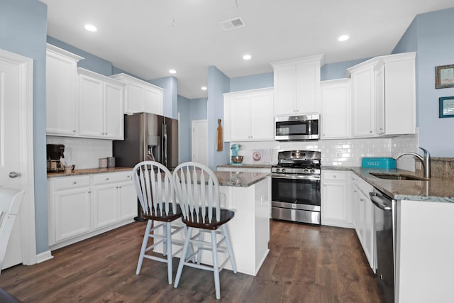 kitchen with dark hardwood / wood-style flooring, white cabinetry, sink, and appliances with stainless steel finishes