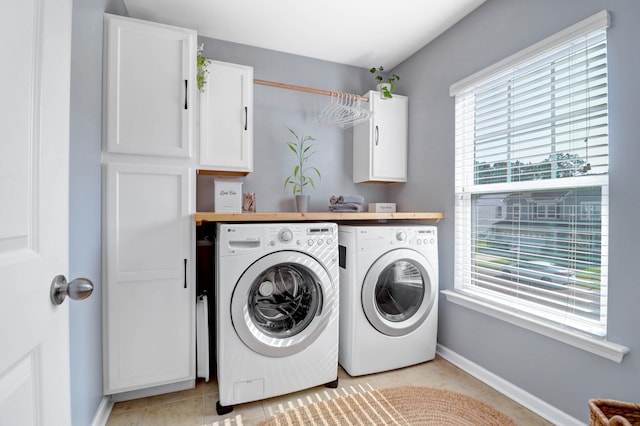 laundry room featuring light tile patterned flooring, cabinets, and independent washer and dryer