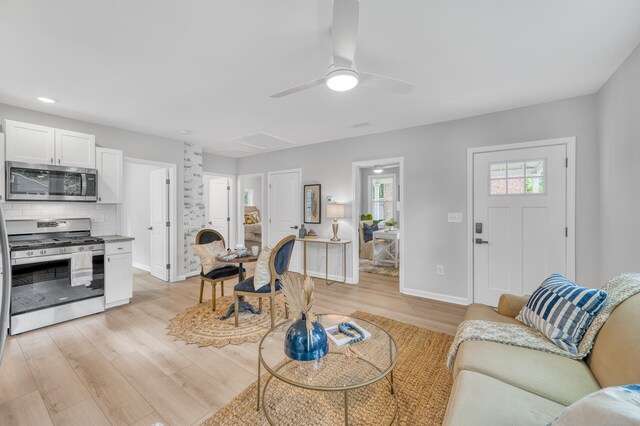 living room featuring ceiling fan and light hardwood / wood-style floors