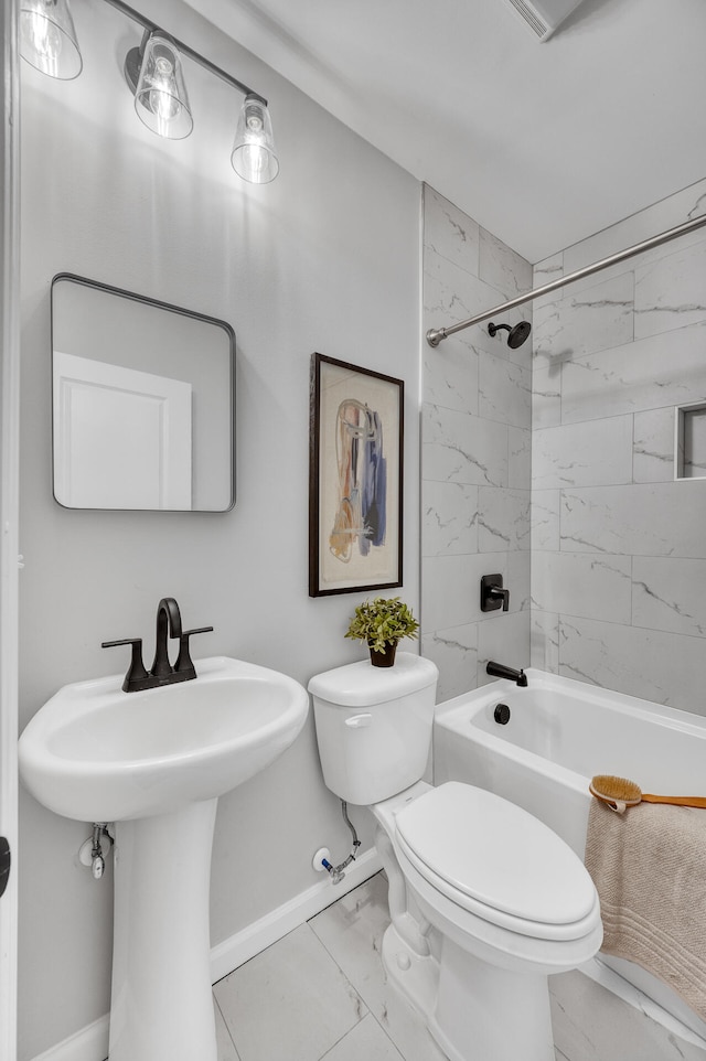 bathroom with tiled shower / bath combo and toilet