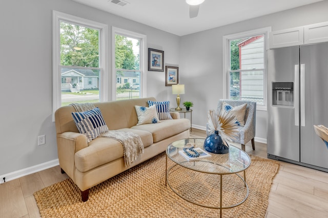 living room with light wood-type flooring, plenty of natural light, and ceiling fan