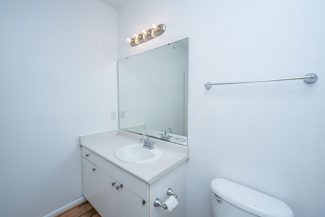 bathroom featuring toilet, hardwood / wood-style floors, and vanity