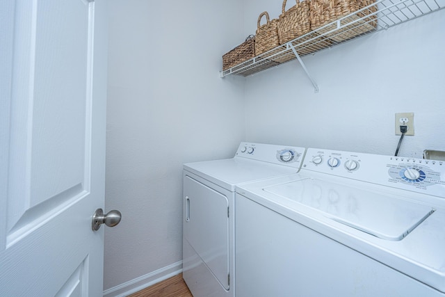 clothes washing area featuring separate washer and dryer and wood-type flooring