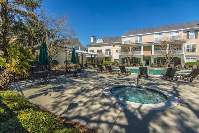 view of swimming pool featuring a pergola, a patio, and a community hot tub