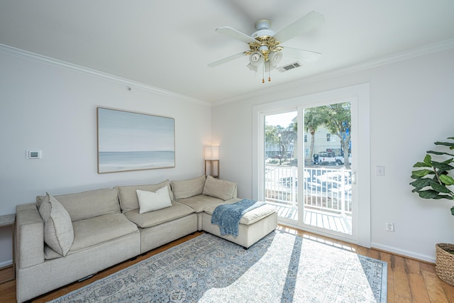 living room featuring ceiling fan, light wood-type flooring, and crown molding