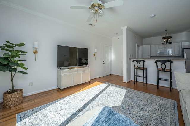 living room featuring ceiling fan, crown molding, and hardwood / wood-style flooring