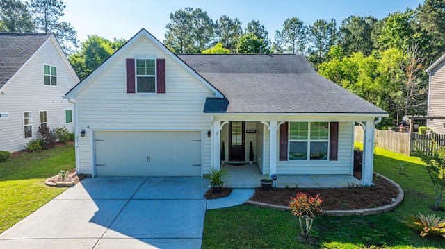 traditional home featuring a porch, a front lawn, fence, and driveway