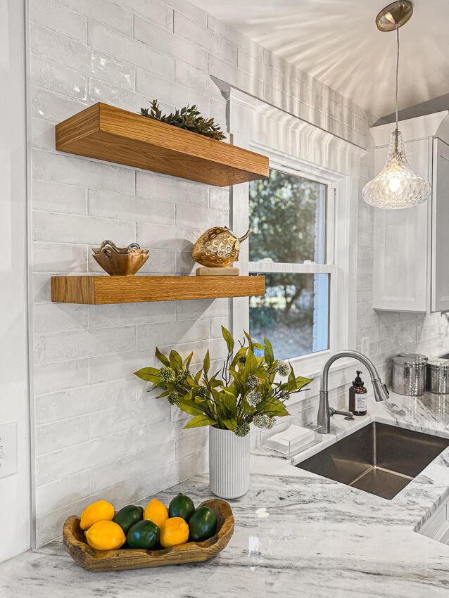 kitchen with light stone counters, sink, decorative light fixtures, and tasteful backsplash