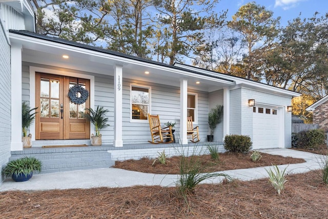 entrance to property with a garage and a porch