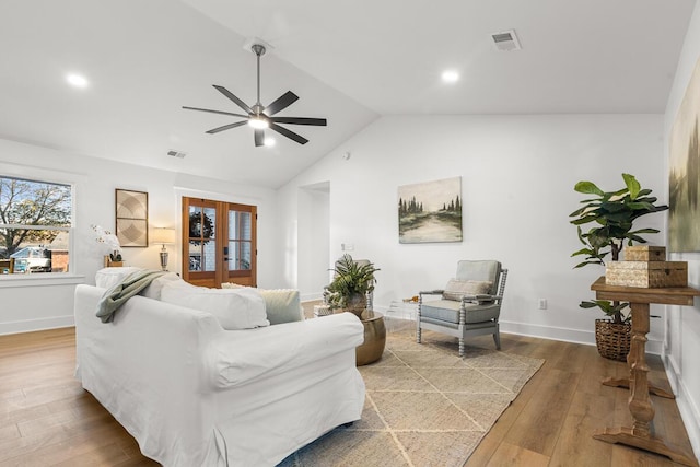 living room featuring lofted ceiling, hardwood / wood-style floors, ceiling fan, and french doors