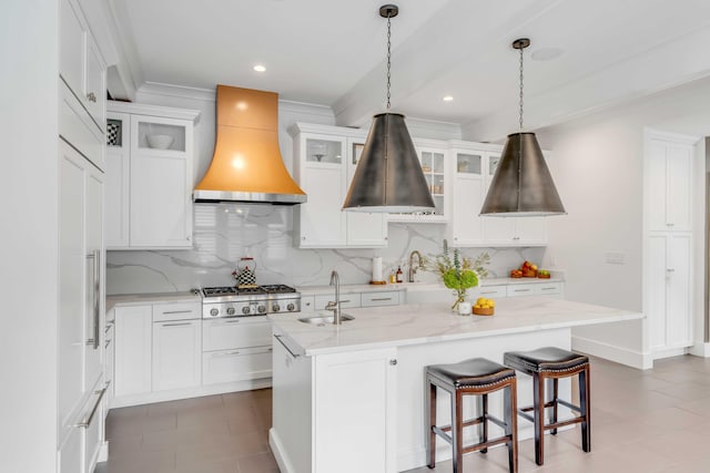 kitchen with crown molding, a center island with sink, custom exhaust hood, and a sink