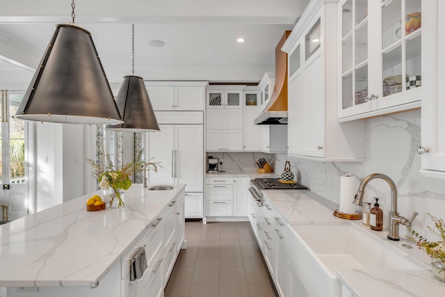 kitchen featuring tasteful backsplash, white cabinets, a sink, and paneled built in refrigerator