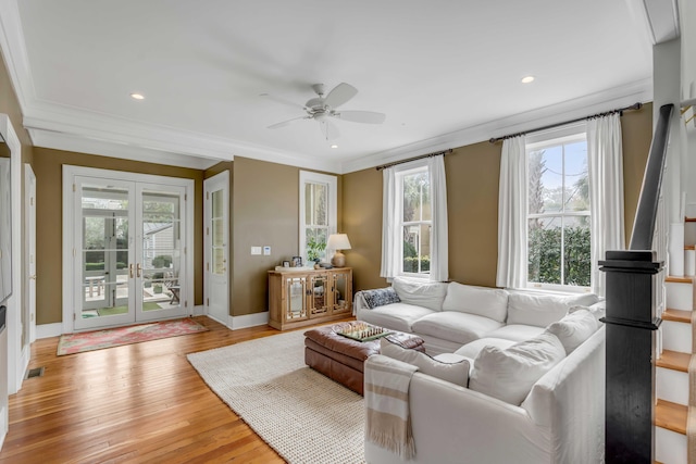 living room with ornamental molding, french doors, light wood finished floors, and baseboards