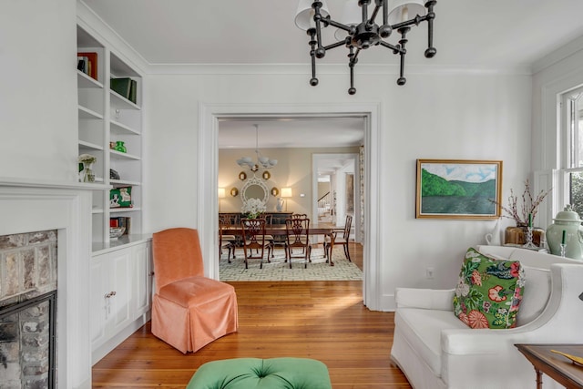 living area featuring crown molding, a notable chandelier, and light wood-style flooring