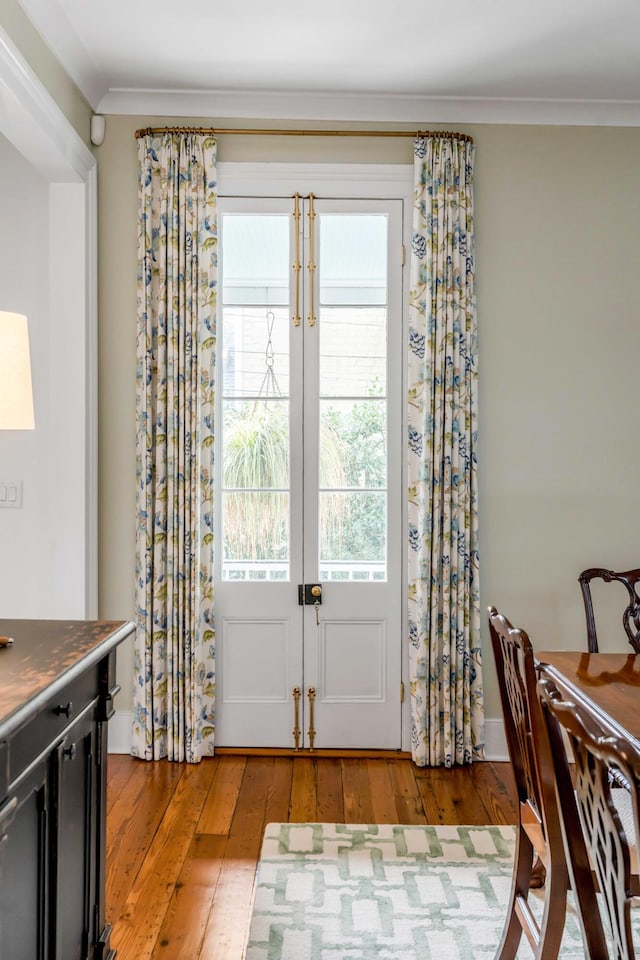 entryway with light wood-style floors and ornamental molding