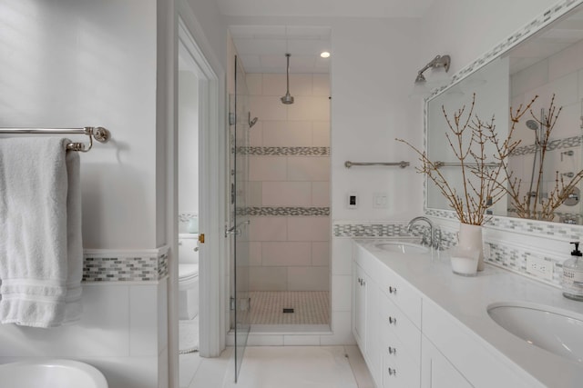 full bath with double vanity, a sink, toilet, and a shower stall