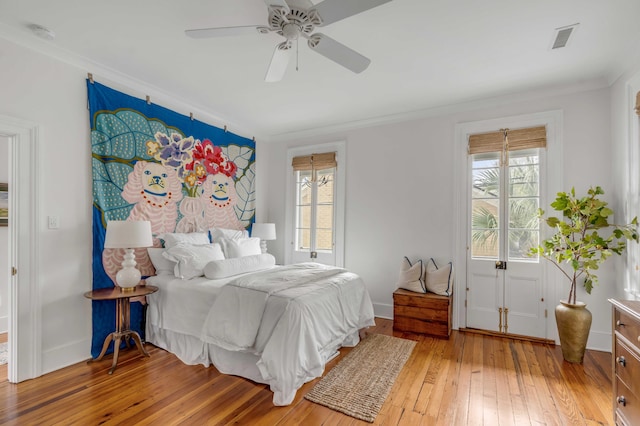 bedroom featuring crown molding, multiple windows, visible vents, and light wood-style floors