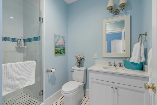 full bathroom featuring toilet, a shower stall, vanity, baseboards, and tile patterned floors