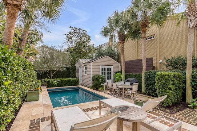 pool with a patio area, an outdoor structure, a storage structure, and fence