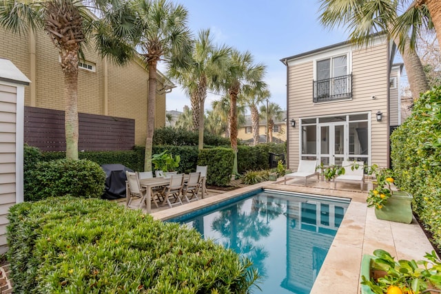 view of swimming pool with a fenced in pool, a patio, a sunroom, a grill, and fence