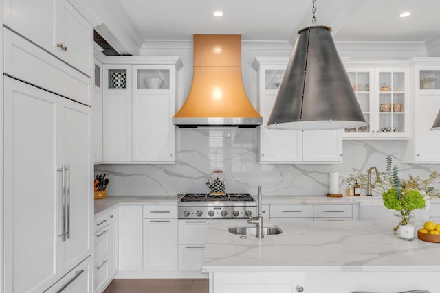 kitchen with premium range hood, a sink, and white cabinetry