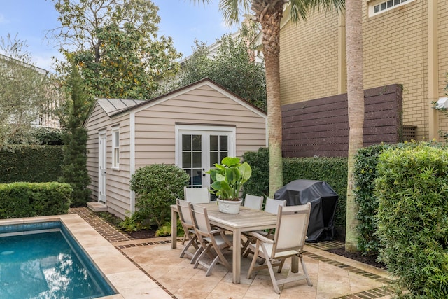 view of patio / terrace featuring an outdoor pool, area for grilling, an outbuilding, french doors, and outdoor dining space