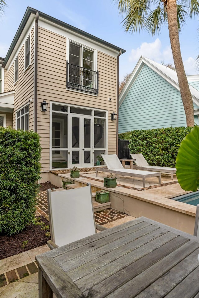 rear view of property with french doors and a wooden deck