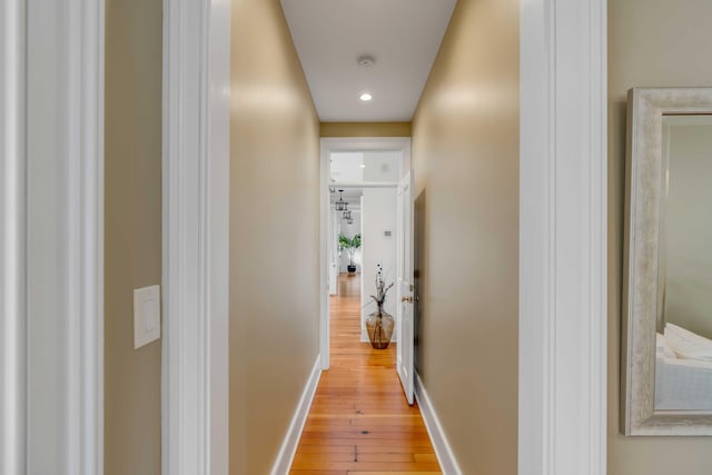 hall with light wood-type flooring and baseboards