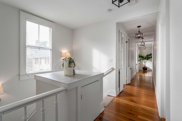 corridor with baseboards and hardwood / wood-style floors