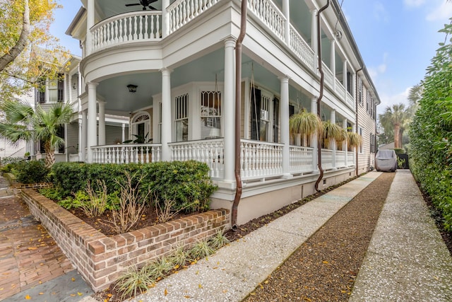 view of side of property with covered porch and a balcony