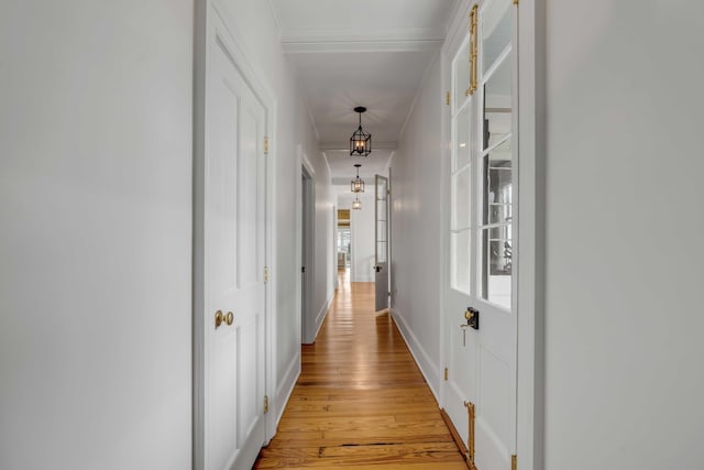 hallway featuring baseboards and light wood finished floors