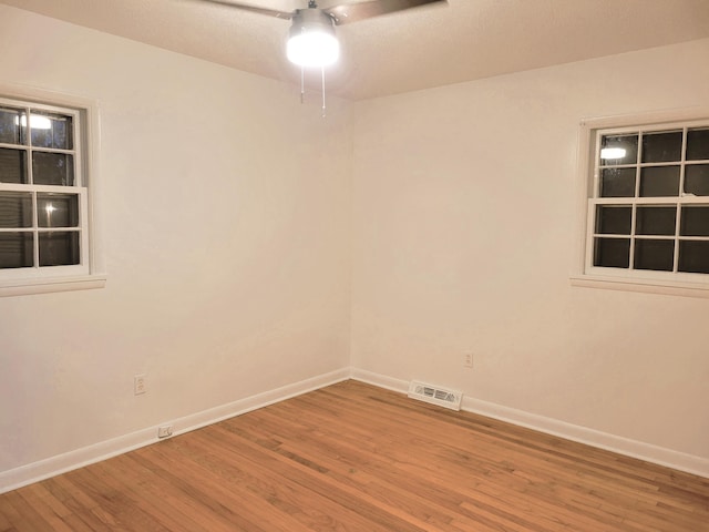 empty room with ceiling fan and hardwood / wood-style floors